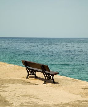 Empty wooden bench with a viewpoint looking out to sea.
