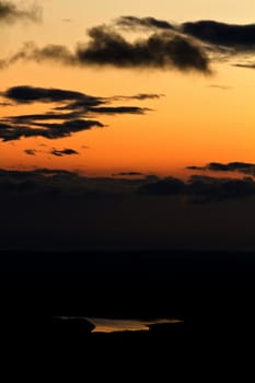 Beautiful view of a sunset landscape with clouds and a lake.