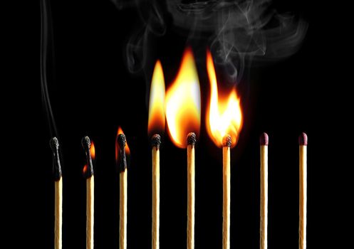 Set of eight matches burning in a chain reaction