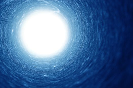 Shot of a cylindrical pipe with strong light at the end, metaphor for hope.