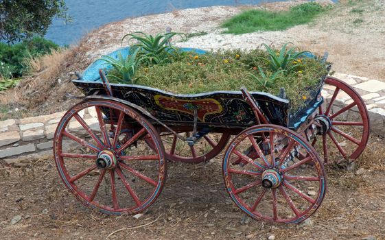 Old wooden cart full of  flowers .