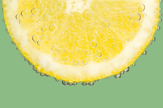 Fizzy Lemon Slice with Bubbles on Cool Green Background