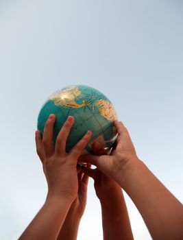 The globe in children's hands.