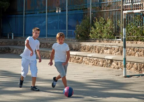 Teenage boys playing soccer at sunny day .