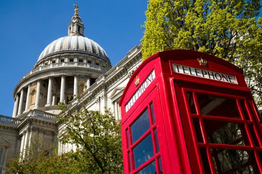 A red London phone box with the dome of St Paul's Cathedral in the background