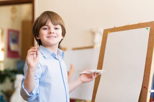 portrait of a boy standing next to his easel, a drawing lesson