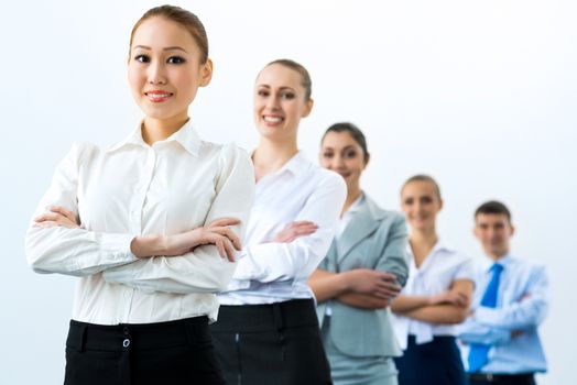 group of business people standing in a row, smiling and crossing his arms