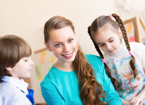 children draw with the teacher in the classroom drawing