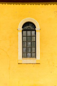 Window and yellow wall on an old colonial style church