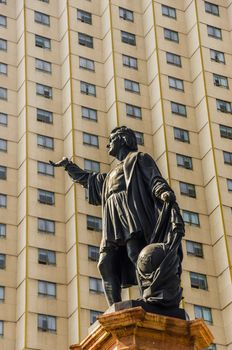 Statue of Christopher Columbus with a building forming an interesting pattern behind