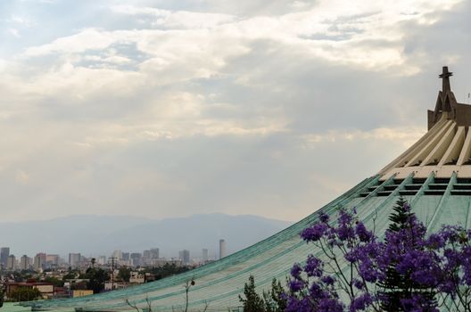 Roof of the Basilica of our Lady of Guadalupe with Mexico City skyscrapers in the background