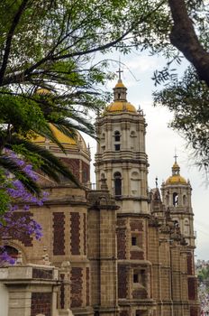 Old Basilica of our Lady of Guadalupe being framed by trees in Mexico City