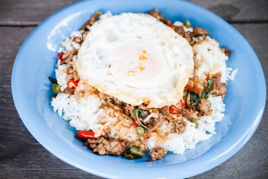 Thai spicy food, rice topped with stir fried pork and basil with fried egg