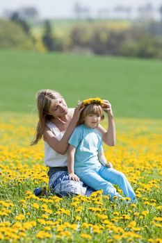 mother and son picking flowers at dandelions field in spring