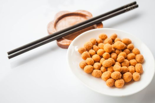 Peanuts snack coated with spicy seasoning and chopsticks
