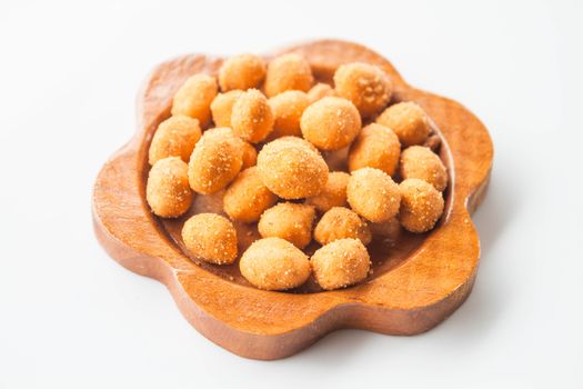 A mound of spicy peanut snack in wood dish