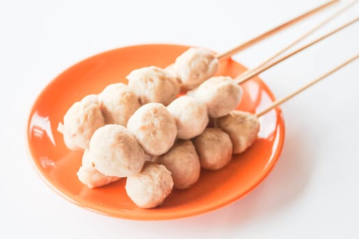 Mini pork balls in orange dish on clean table