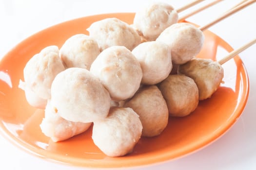 Mini pork balls in orange dish on clean table