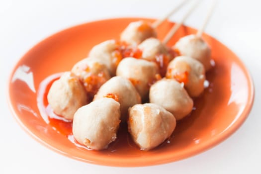 Mini pork balls in orange dish on clean table