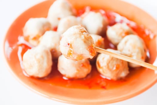 Mini pork balls in orange dish on clean table