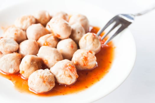 Mini pork balls in orange dish on clean table