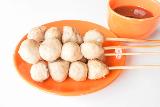 Mini pork balls in orange dish on clean table