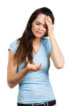 A woman suffering from headache or migraine holding a painkiller pill. Isolated on white.