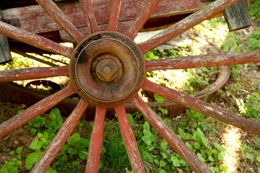 A Old weathered red wagon wheel