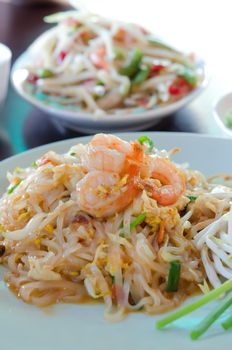 close up stir fried  noodles with shrimp , egg  and fresh vegetable , asian style cuisine on table