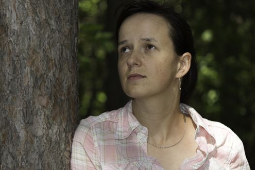 Young woman in the forest thinking