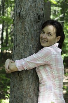 Young woman hugging a tree