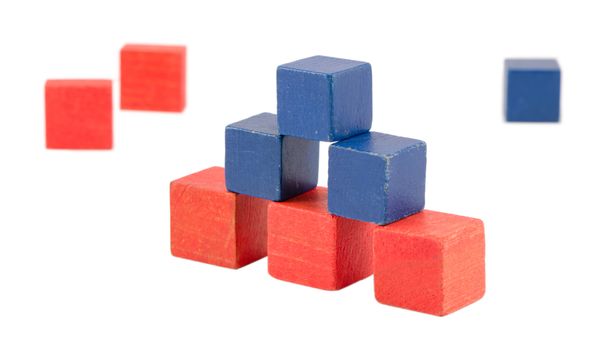 pyramid made of wood colorful toy log bricks blocks isolated on white. pink blue color construction.