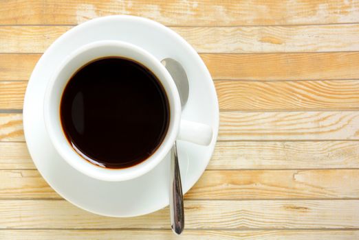 Black coffee in white cup on a wooden table 