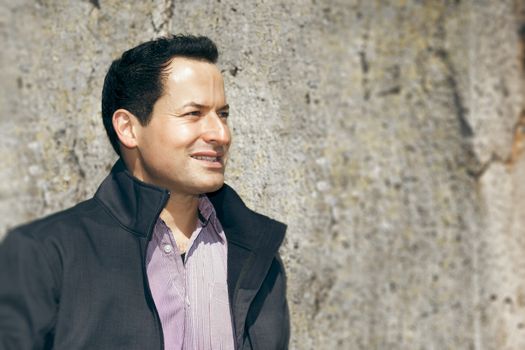 A man in front of a natural stone wall