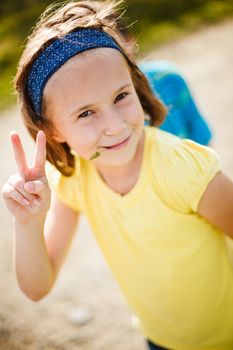 Girl smiling and doing a peace sign