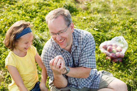 Father teaching how to whistle with grass to his daughter