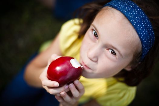 Cute little girl eating an apple