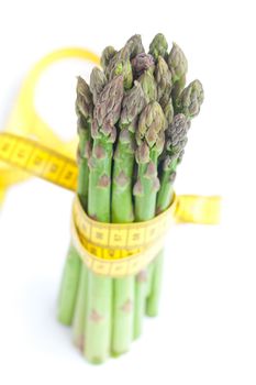 asparagus tied with measuring tape isolated on white