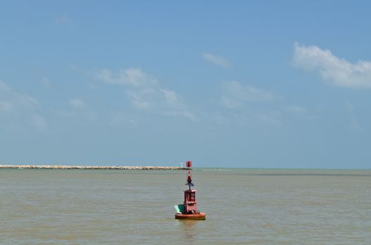 Red buoy floating in the sea in blue sky day