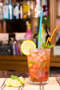 Strawberry mojito on a bar counter against the background of the shelves