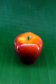 red apple lookchoob thai dessert on banana leaf, lookchoob is thai dessert included greenbean, sugar and jelly.