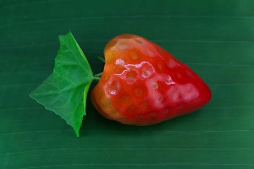 stawberry lookchoob thai dessert on banana leaf, lookchoob is thai dessert included greenbean, sugar and jelly.