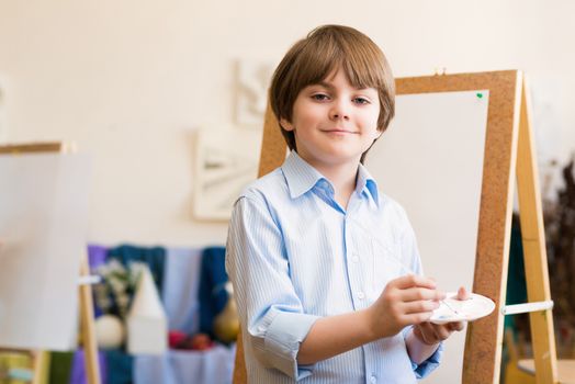 portrait of a boy standing next to his easel, a drawing lesson