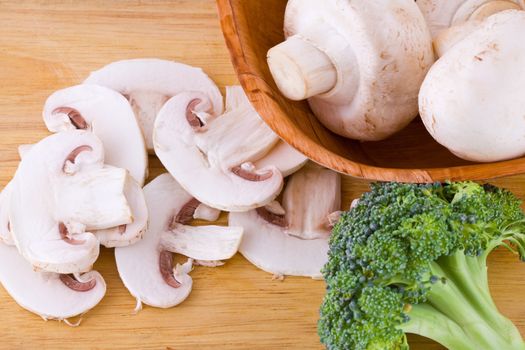 Mushrooms and broccoli on the wooden cutting board