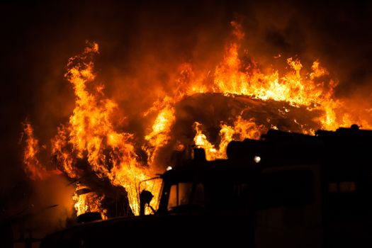 Arson or nature disaster - burning fire flame on wooden house roof