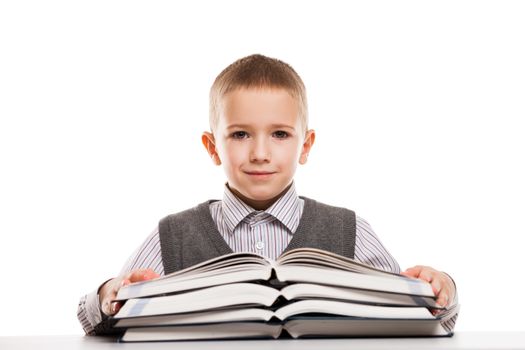 Little smiling child boy reading education books at desk