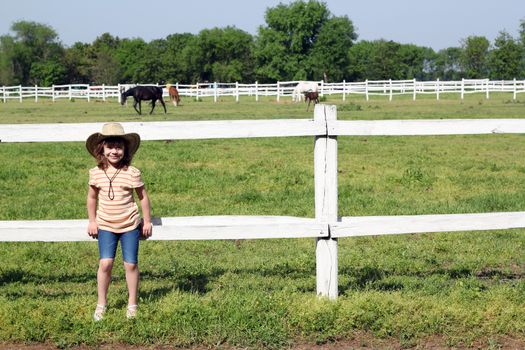 little girl and horses in corral