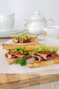 Cured ham sandwich with tomatoes for breakfast with a cup of coffee