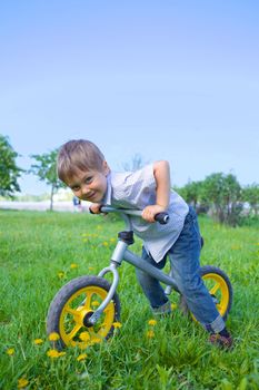 Little boy on a bicycle in the summer park