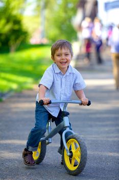 Little boy on a bicycle in the summer park